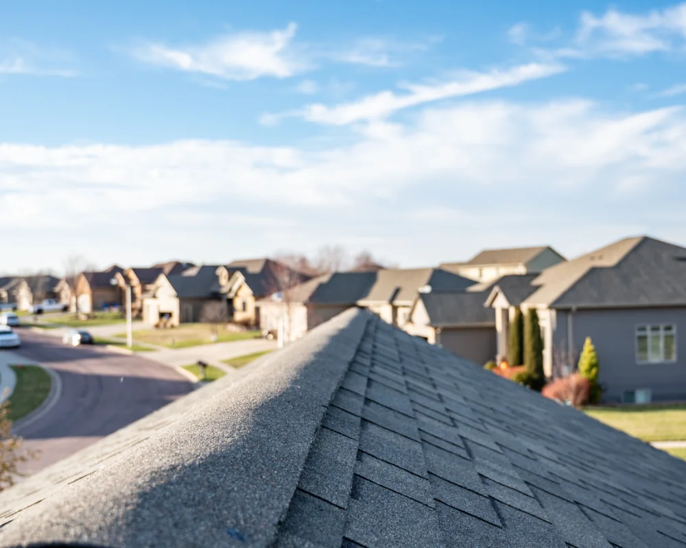 Landscape photograph of a suburban neighborhood taken from the top of newly installed roof.